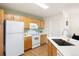 Functional kitchen featuring white appliances, wooden cabinets, quartz countertops and a modern faucet at 5735 N Genoa Way # 11-205, Aurora, CO 80019