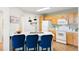 Bright kitchen with modern appliances, quartz counters, and eat-in island with blue chairs, perfect for gatherings at 5735 N Genoa Way # 11-205, Aurora, CO 80019