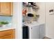 Convenient laundry room with modern washer, dryer, storage shelves, and storage cabinet at 5735 N Genoa Way # 11-205, Aurora, CO 80019