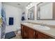 Bright bathroom with double sinks, wooden vanity, and a shower with blue accents at 9047 Apache Plume Dr # D, Parker, CO 80134