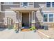 A welcoming front porch with stone pillars, potted plants, and a 'Welcome' mat at 9047 Apache Plume Dr # D, Parker, CO 80134