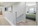 Second floor hallway with carpet and white wood banister leading to a bedroom at 9047 Apache Plume Dr # D, Parker, CO 80134