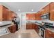 Spacious kitchen featuring dark cabinets, stainless steel appliances, and tile flooring at 9047 Apache Plume Dr # D, Parker, CO 80134