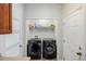 Functional laundry room featuring modern washer and dryer with storage shelf and plenty of light at 9047 Apache Plume Dr # D, Parker, CO 80134