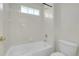 Bright bathroom featuring a tiled shower and tub combination with updated fixtures and glass-block window at 1311 S Kingston St, Aurora, CO 80012