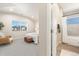 Bedroom leading to bathroom features neutral colors, carpet, and natural lighting at 875 E 78Th Ave # 70, Denver, CO 80229