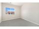 Bright bedroom featuring a large window offering neighborhood views and neutral carpeting at 875 E 78Th Ave # 70, Denver, CO 80229