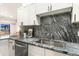 Modern kitchen featuring marble countertops, stainless steel appliances, and stylish white cabinets at 875 E 78Th Ave # 70, Denver, CO 80229