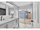 Modern bathroom with dual sinks, new vanity, and sliding glass doors to backyard at 6680 E Rustic Dr, Parker, CO 80138