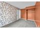 Cozy bedroom with floral wallpaper, neutral carpet, and closet storage at 6680 E Rustic Dr, Parker, CO 80138