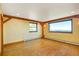 Sunlit bedroom with hardwood floors, exposed wooden beams, and large windows offering scenic views at 33090 Janelle Cir, Golden, CO 80403