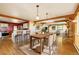 Open dining room featuring wooden beams, hardwood floors, and views of the modern kitchen area at 33090 Janelle Cir, Golden, CO 80403