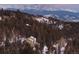 Scenic exterior view of a home nestled in a snow-dusted forest with mountains in the backdrop at 33090 Janelle Cir, Golden, CO 80403