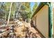 Side exterior of a cabin, deck, adjacent landscape, stairs, and retaining wall at 33090 Janelle Cir, Golden, CO 80403