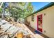 Side exterior view of a cabin, showing the siding, wood deck, and surrounding landscape at 33090 Janelle Cir, Golden, CO 80403