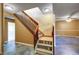 Staircase with a wood railing, leading to a lower level that features a colorful concrete floor at 33090 Janelle Cir, Golden, CO 80403