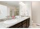 Stylish bathroom with double sinks, granite counters, dark cabinets, and a glass shower at 12513 Grape St, Thornton, CO 80241