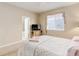Comfortable bedroom featuring carpet, television, and a bright window at 12513 Grape St, Thornton, CO 80241