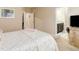 Bright bedroom featuring carpet, neutral walls, television, and ensuite bath at 12513 Grape St, Thornton, CO 80241
