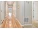 Long hallway with hardwood floors, neutral paint, and white trim at 12513 Grape St, Thornton, CO 80241