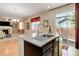 Granite countertops and stainless steel sink in kitchen with a view of backyard and adjoining living room at 12513 Grape St, Thornton, CO 80241