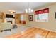 Bright living room with fireplace, ceiling fan, wood flooring, and many windows at 12513 Grape St, Thornton, CO 80241