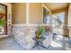 Covered porch with stone accents and outdoor seating at 12513 Grape St, Thornton, CO 80241