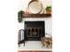 Close-up of brick fireplace featuring a wood mantel, decorative mirror, and hearth at 19738 Applewood Ct, Parker, CO 80138