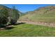 Backyard with lush green grass, landscaping, and a view of the surrounding mountains at 535 High Point Dr, Golden, CO 80403