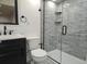 Modern bathroom with a glass-enclosed shower featuring gray tiled walls and a black vanity at 535 High Point Dr, Golden, CO 80403