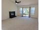 Bright living room features a fireplace, neutral carpet, and sliding glass doors to the outdoors at 535 High Point Dr, Golden, CO 80403