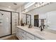 Modern bathroom featuring double sinks, walk-in shower with black trim and stylish lighting at 8733 Arriba Dr, Littleton, CO 80125