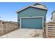 Blue garage with a concrete driveway and a wooden fence at 8733 Arriba Dr, Littleton, CO 80125