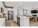 Open concept kitchen flows into the living area, with stainless steel appliances, and island with sink at 8733 Arriba Dr, Littleton, CO 80125