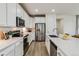 Modern kitchen featuring white cabinets, quartz countertops, stainless steel appliances, and an undermount sink at 8733 Arriba Dr, Littleton, CO 80125