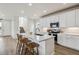 Bright kitchen with center island, seating, stainless appliances, white cabinets and a contemporary design at 8733 Arriba Dr, Littleton, CO 80125
