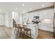 Well-lit modern kitchen featuring an island with bar stool seating, stainless steel appliances, and white cabinetry at 8733 Arriba Dr, Littleton, CO 80125