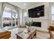 Cozy living area boasts a fireplace, mounted television, and access to the outdoor living space at 8733 Arriba Dr, Littleton, CO 80125