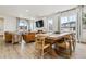 Open living area with dining table, living room set, large windows for natural light, and hardwood floors at 8733 Arriba Dr, Littleton, CO 80125