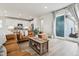 Bright living room features leather sofa, sliding glass doors to patio, and modern, open-concept kitchen at 8733 Arriba Dr, Littleton, CO 80125