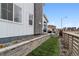 Landscaped side yard with stone retaining wall and view of the neighborhood at 8733 Arriba Dr, Littleton, CO 80125