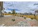 Backyard with stone landscaping, concrete patio, wood fence, and lawn at 15376 Ivanhoe Ct, Thornton, CO 80602