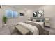 Bedroom with neutral decor, bench, and artwork at 15376 Ivanhoe Ct, Thornton, CO 80602