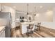 Modern kitchen featuring an island with seating, pendant lighting, and stainless steel appliances at 15376 Ivanhoe Ct, Thornton, CO 80602
