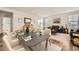 Open-concept living and dining area with modern furnishings, a dark wood table and hardwood floors at 15376 Ivanhoe Ct, Thornton, CO 80602