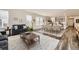 Open-concept living and dining area with modern furnishings, hardwood floors, and natural light at 15376 Ivanhoe Ct, Thornton, CO 80602
