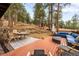 A backyard deck with outdoor furniture offers an inviting space for relaxation and entertaining amidst towering trees at 4986 White House Trl, Evergreen, CO 80439