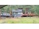 Exterior view of gray two-story home with an attached garage and a large deck at 4986 White House Trl, Evergreen, CO 80439