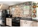 Kitchen with black appliances, decorative tile backsplash, and white cabinetry at 4986 White House Trl, Evergreen, CO 80439