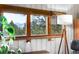 This window has natural wood trim and views of green trees and the distant mountains at 4986 White House Trl, Evergreen, CO 80439
